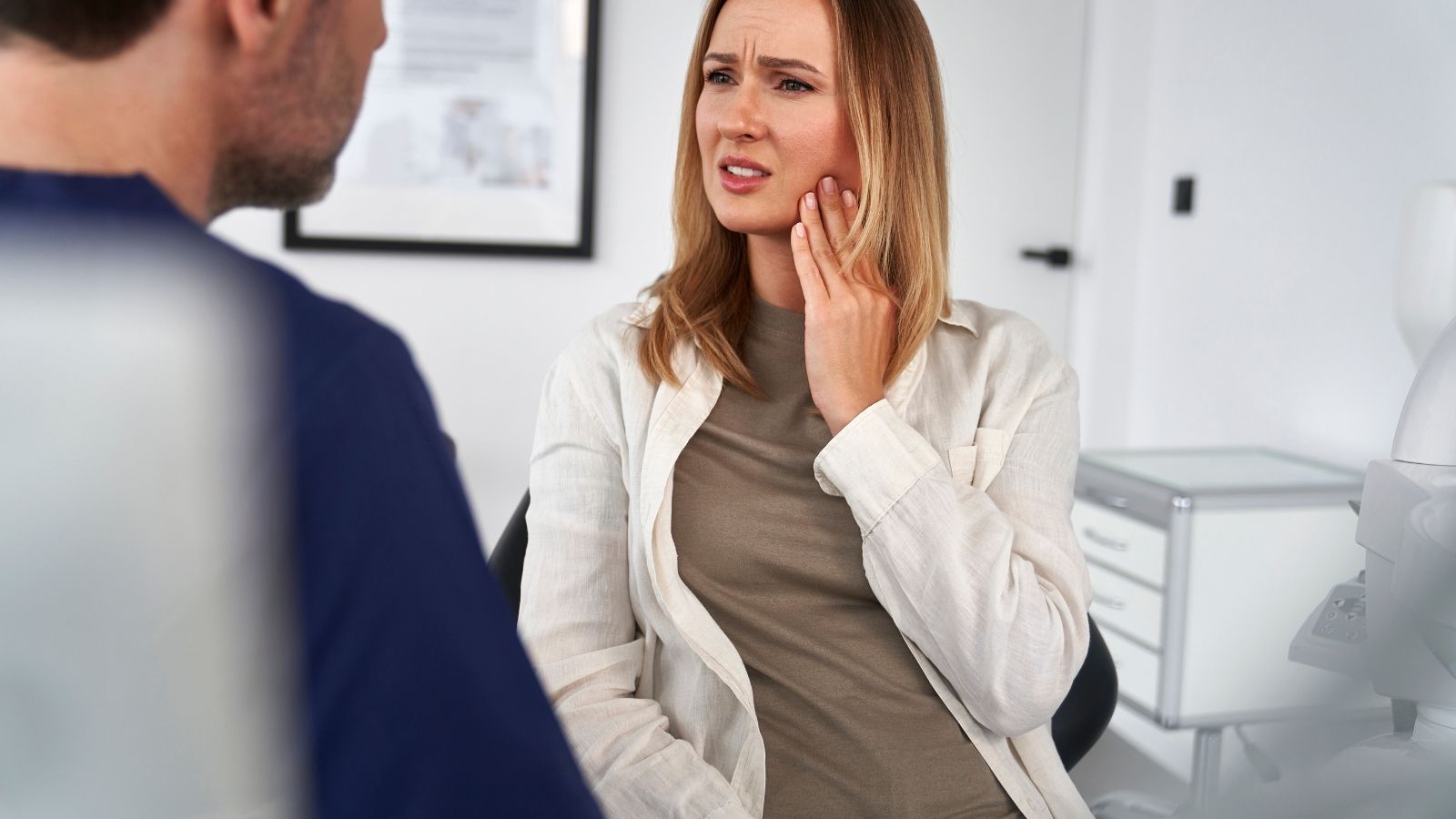 Donna con dolore alla mandibola durante visita odontoiatrica per bruxismo a Caserta